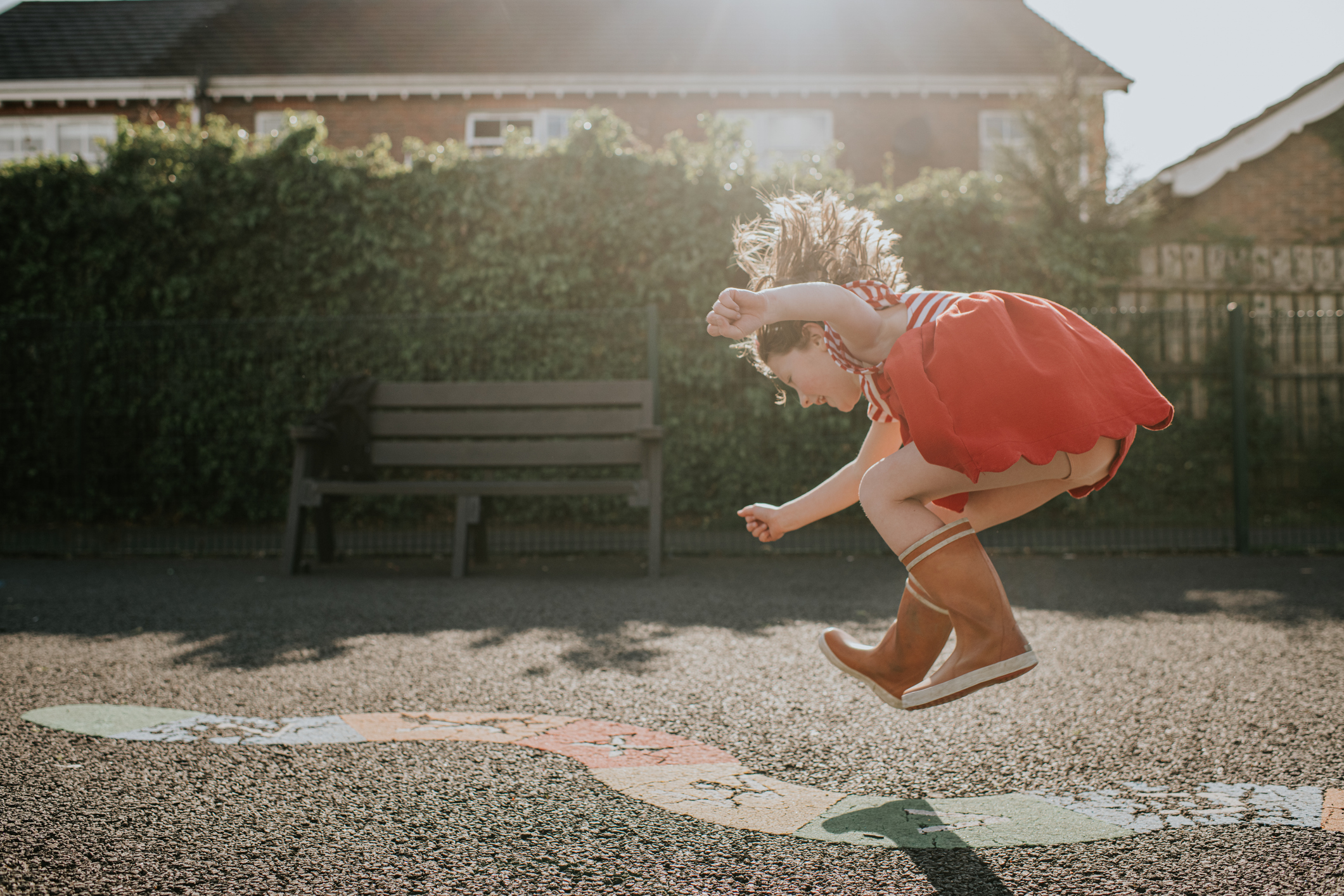 Kislány ugrik a szabadban egy játszótéren