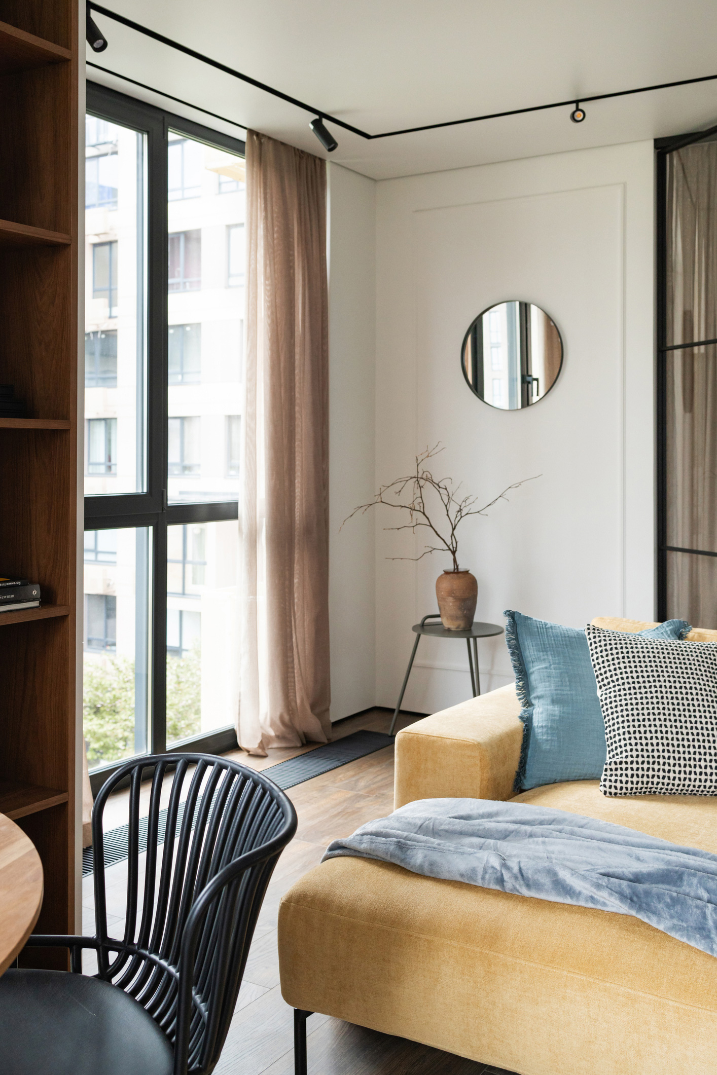 Modern nappali nagy sárga kanapéval az ablak mellett és üveg válaszfallal