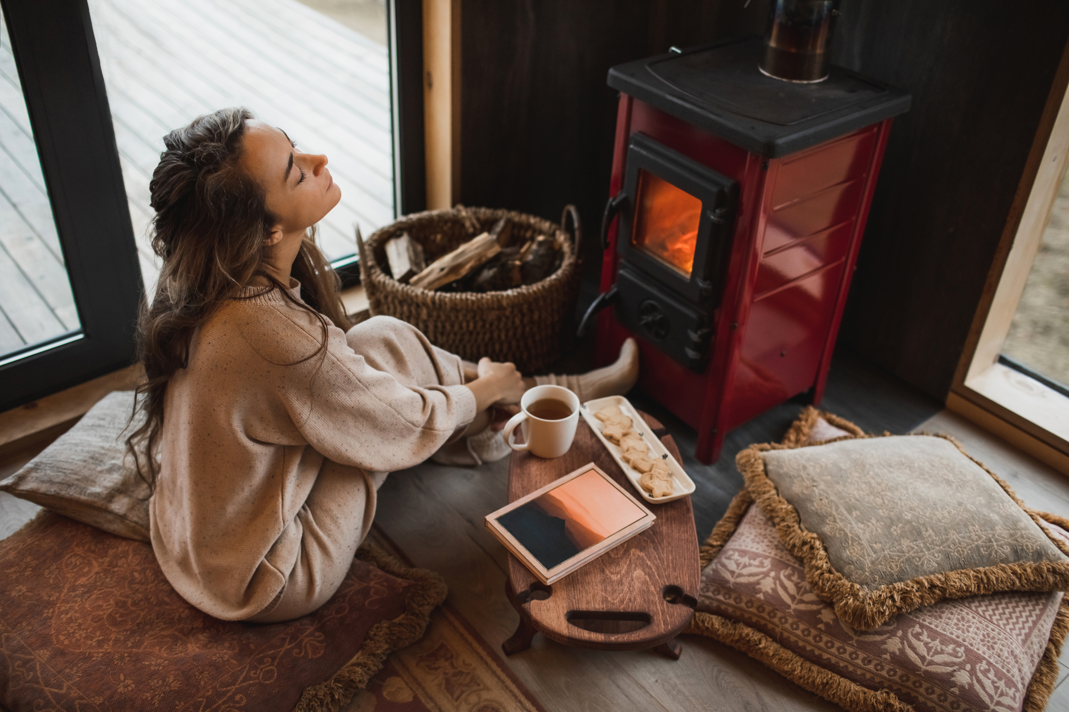 Nő melegszik a kandallónál télen