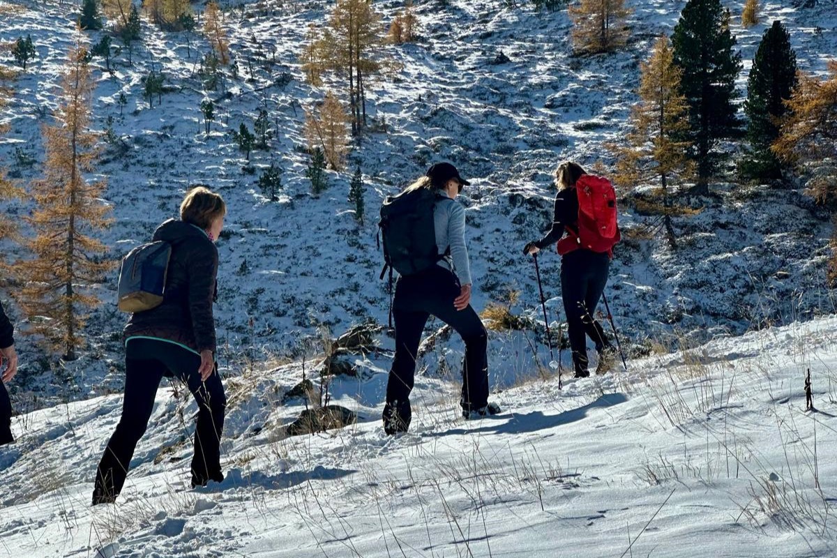 három nő túrázik a hóban