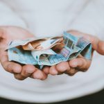 Nő pénzt tart a kezében
