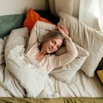 ágyban fekvő szőke nő felülnézetből