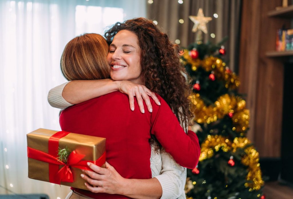karacsonyi-ajandek-szemelyisegteszt-legjobb-ajandek | Marie Claire Két lánytestvér átöleli egymást karácsonyi ajándékozásnál
