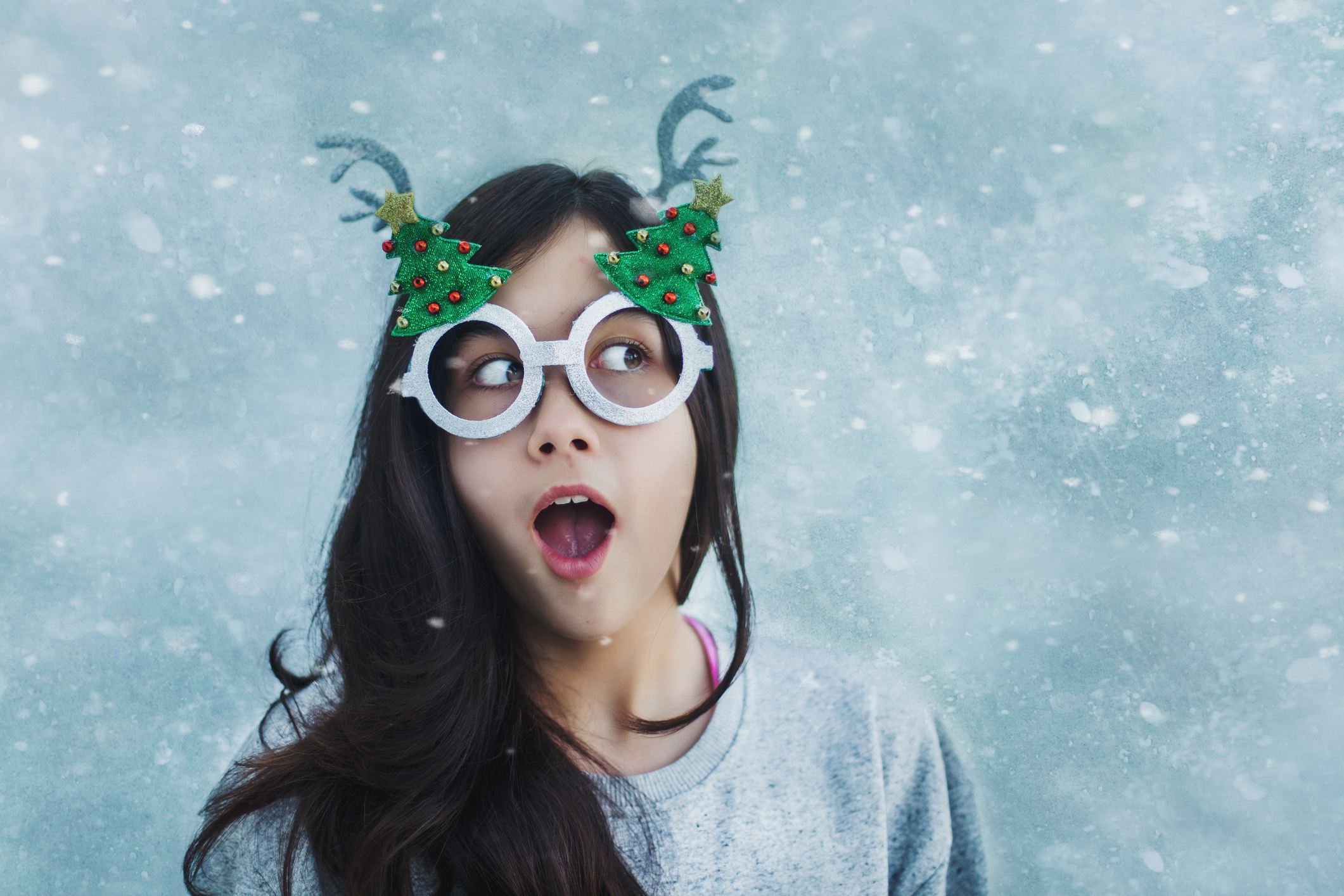 egy barna hajú tinilány karácsonyi vicces szemüvegben és vicces arckifejezéssel