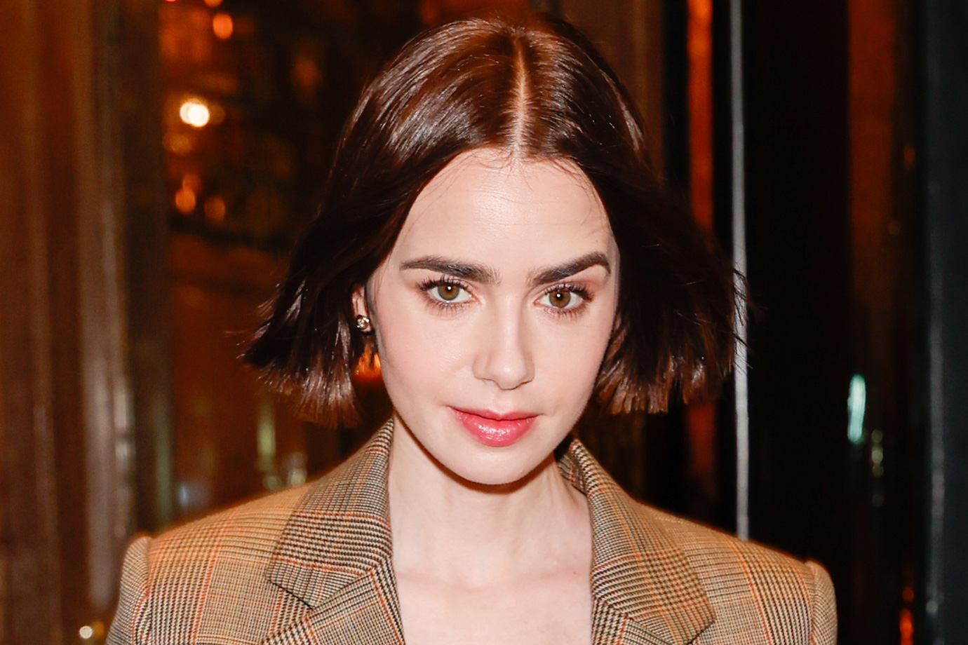 Lily Collins felvont szemöldökkel egy hotelből távozik 2025. december 14-én Párizsban, Franciaországban.
