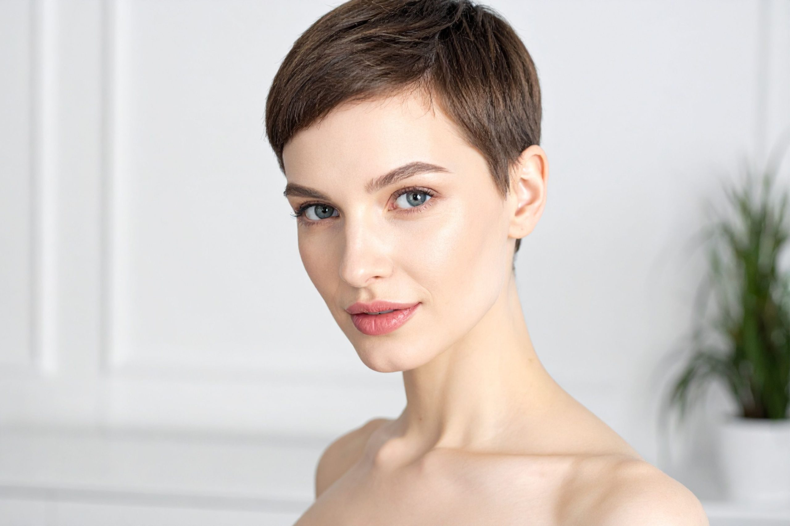 Rövid frizurát viselő fiatal, szép nő közeli portréja