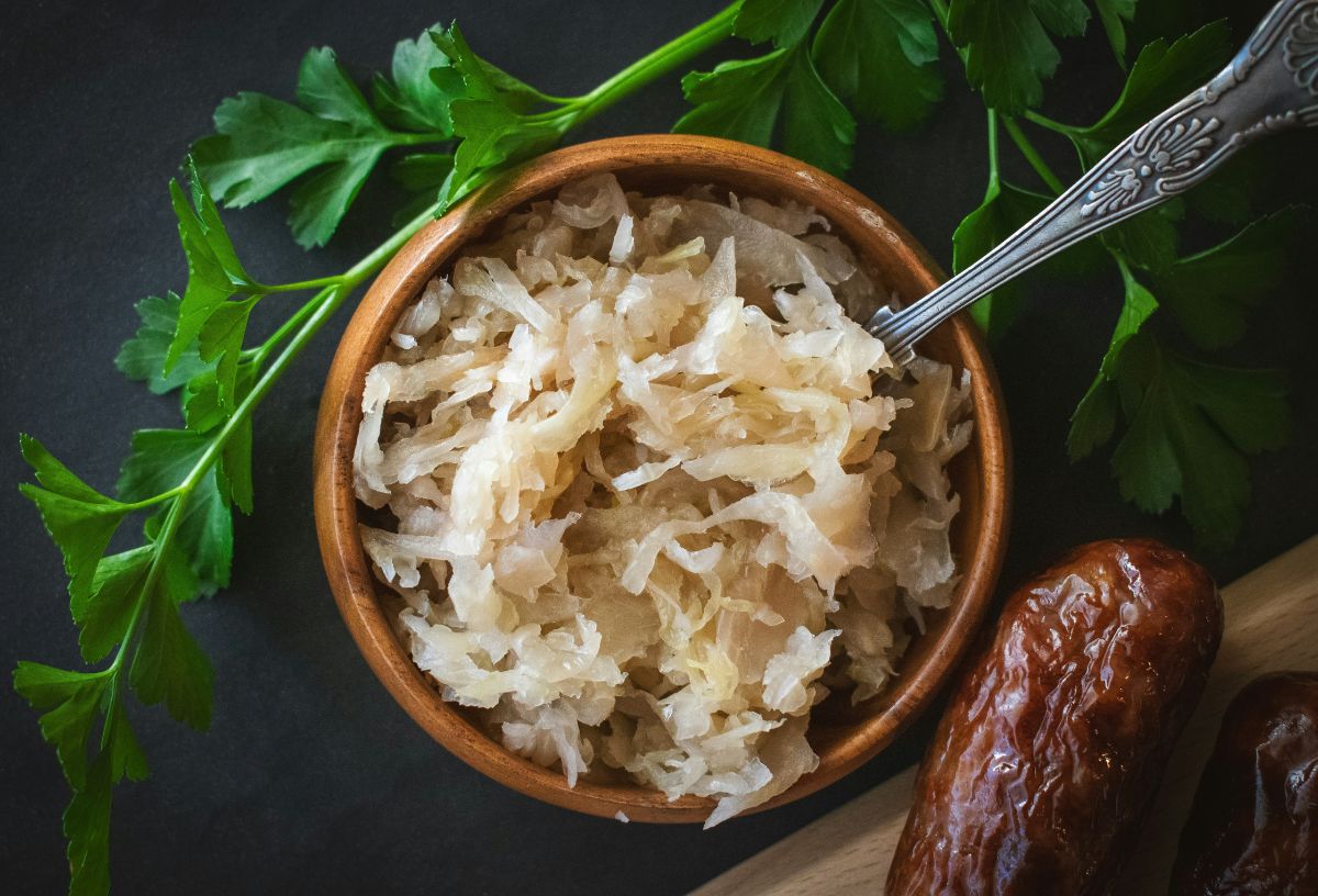 Savanyúkáposzta barna kerámiatálban, benne villa, mögötte petrezselyemzöld