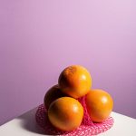 Három narancs lilás háttér előtt