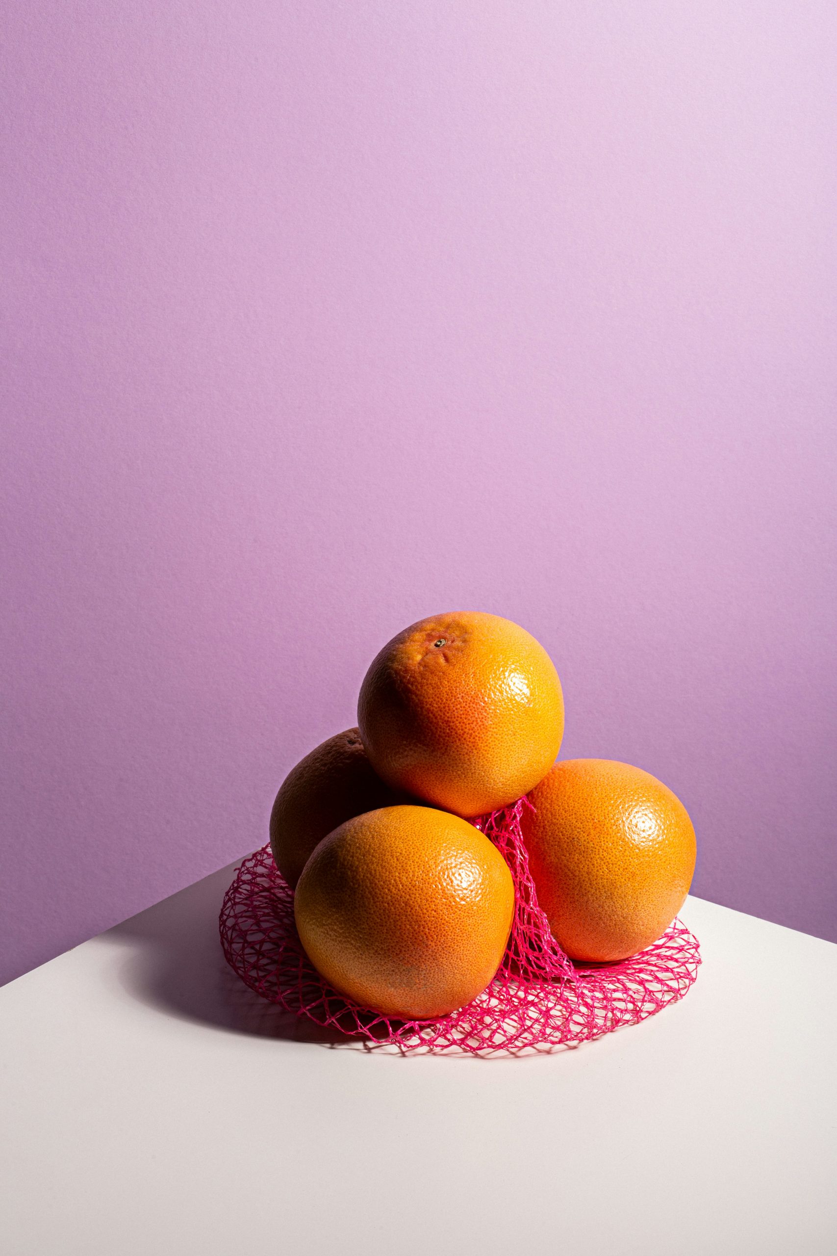 Három narancs lilás háttér előtt