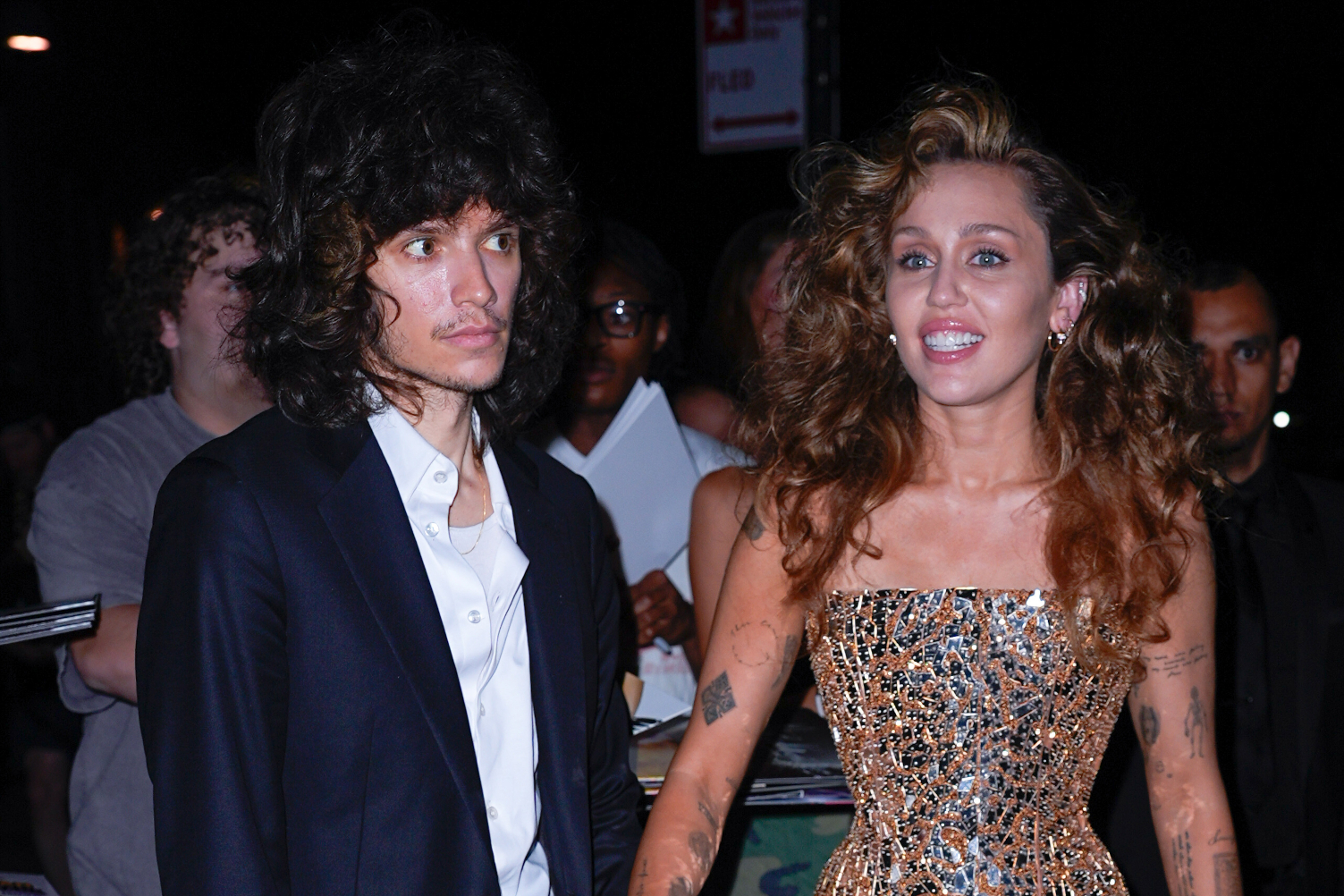 Miley Cyrus csillogó estélyiben és párja, Maxx Morando hosszú hajjal, öltönyben