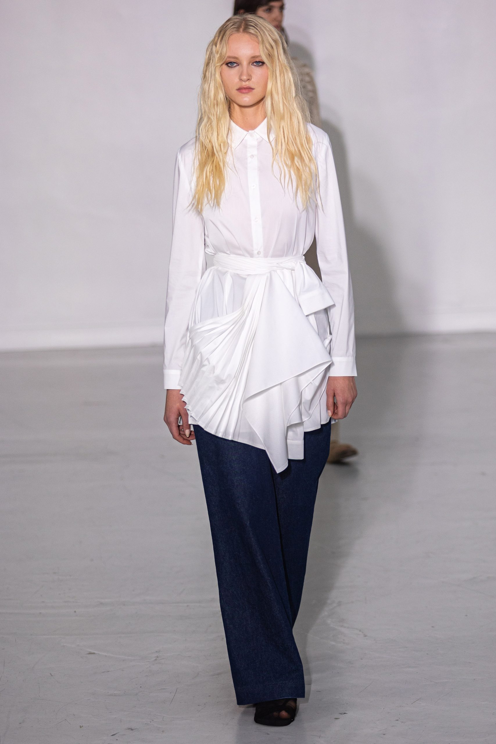 Modell blúz-farmer kombinációban vonul a kifutón