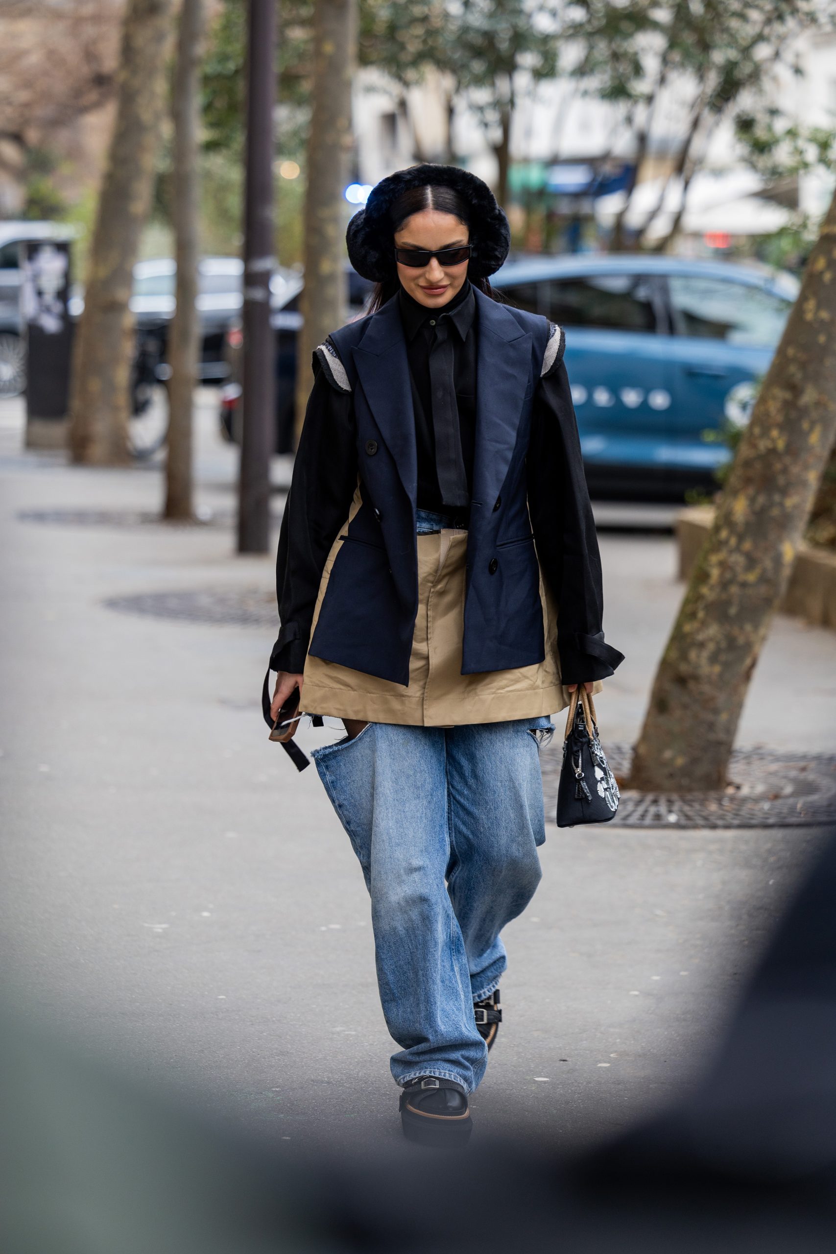 Fiatal nő fülmelegítőben sétál az utcán