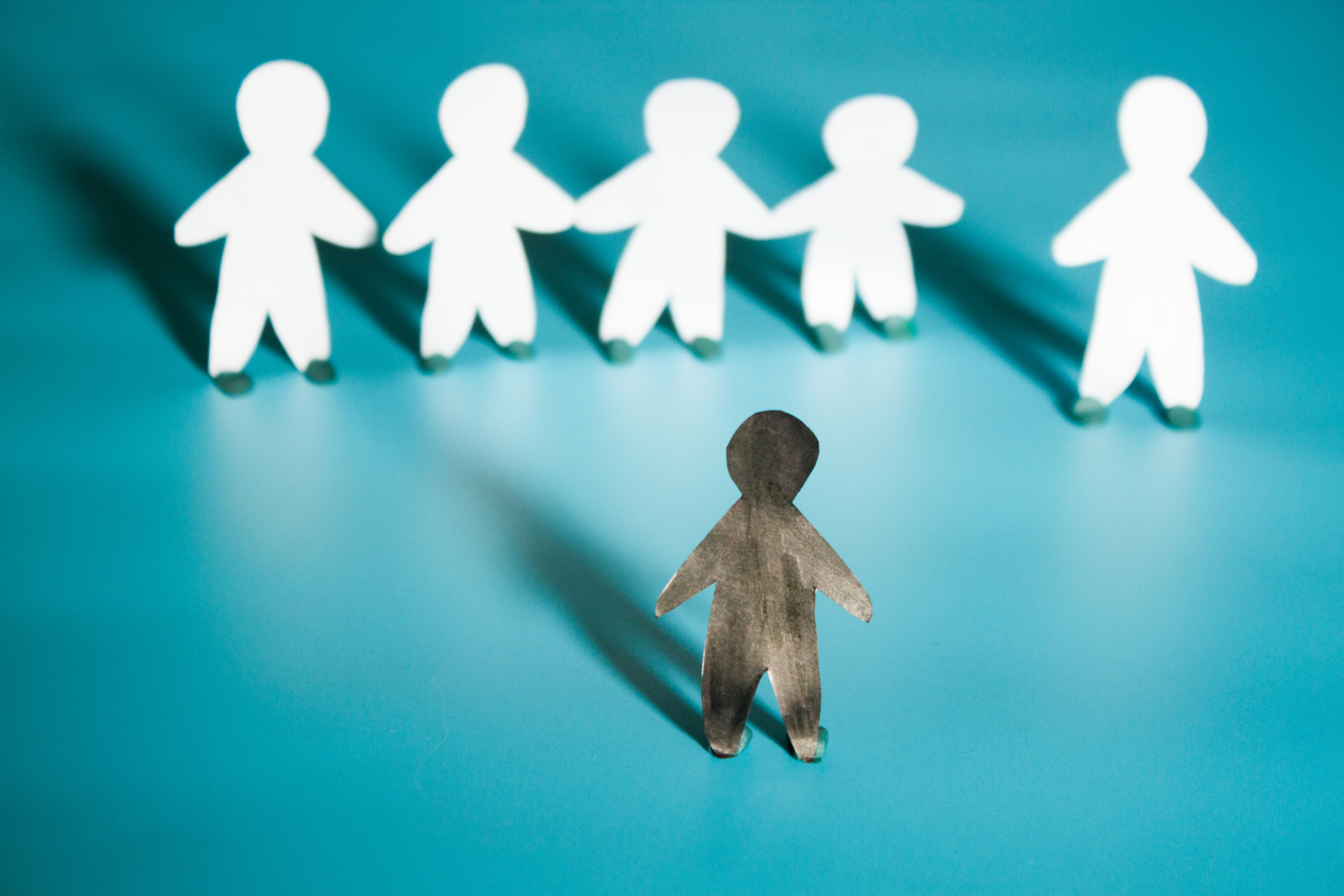 A rasszizmus fogalmának képi ábrázolása. Fehér papírból készült ember fekete papírból készült emberrel szemben.