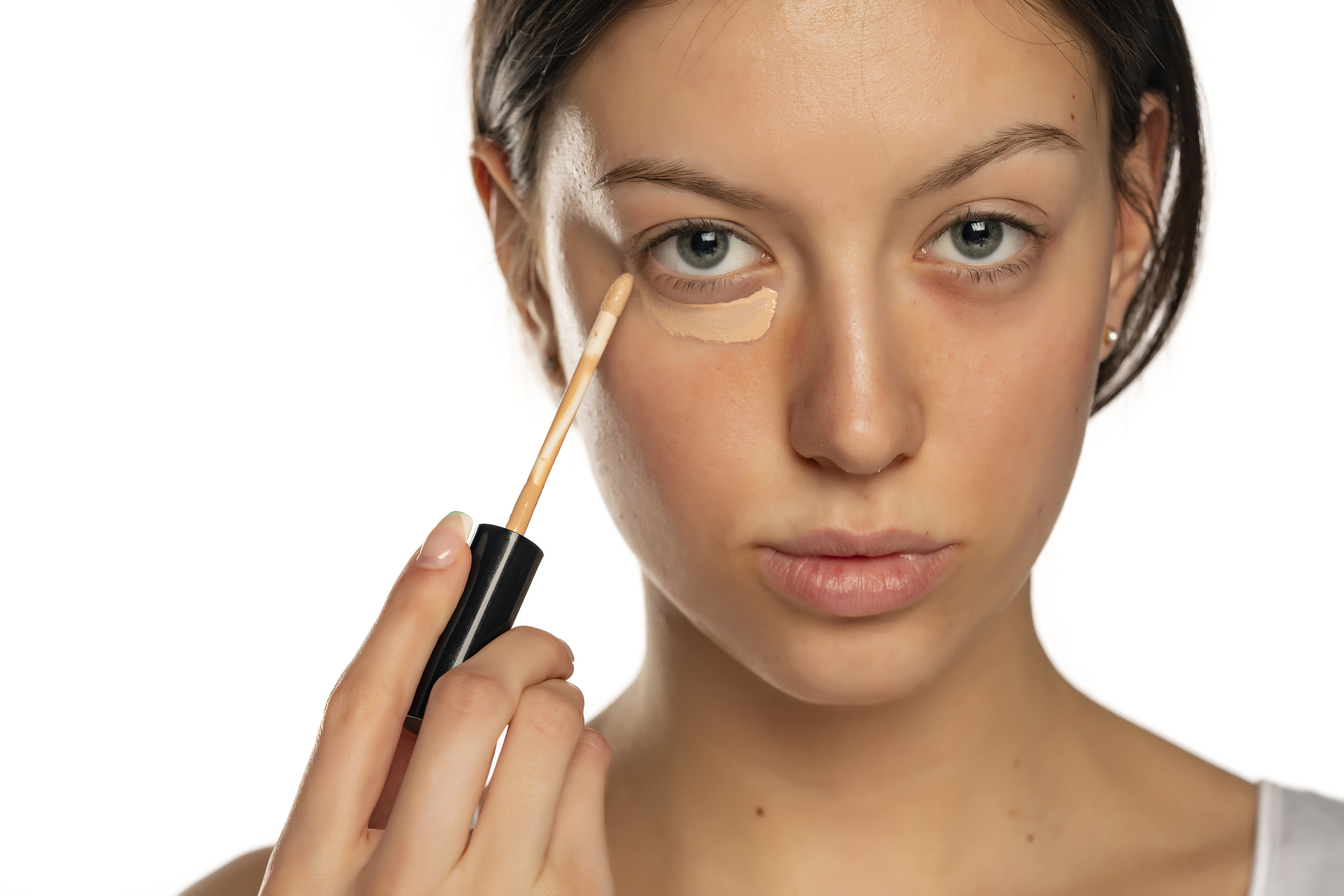 Nő korrektort ken a szeme alá