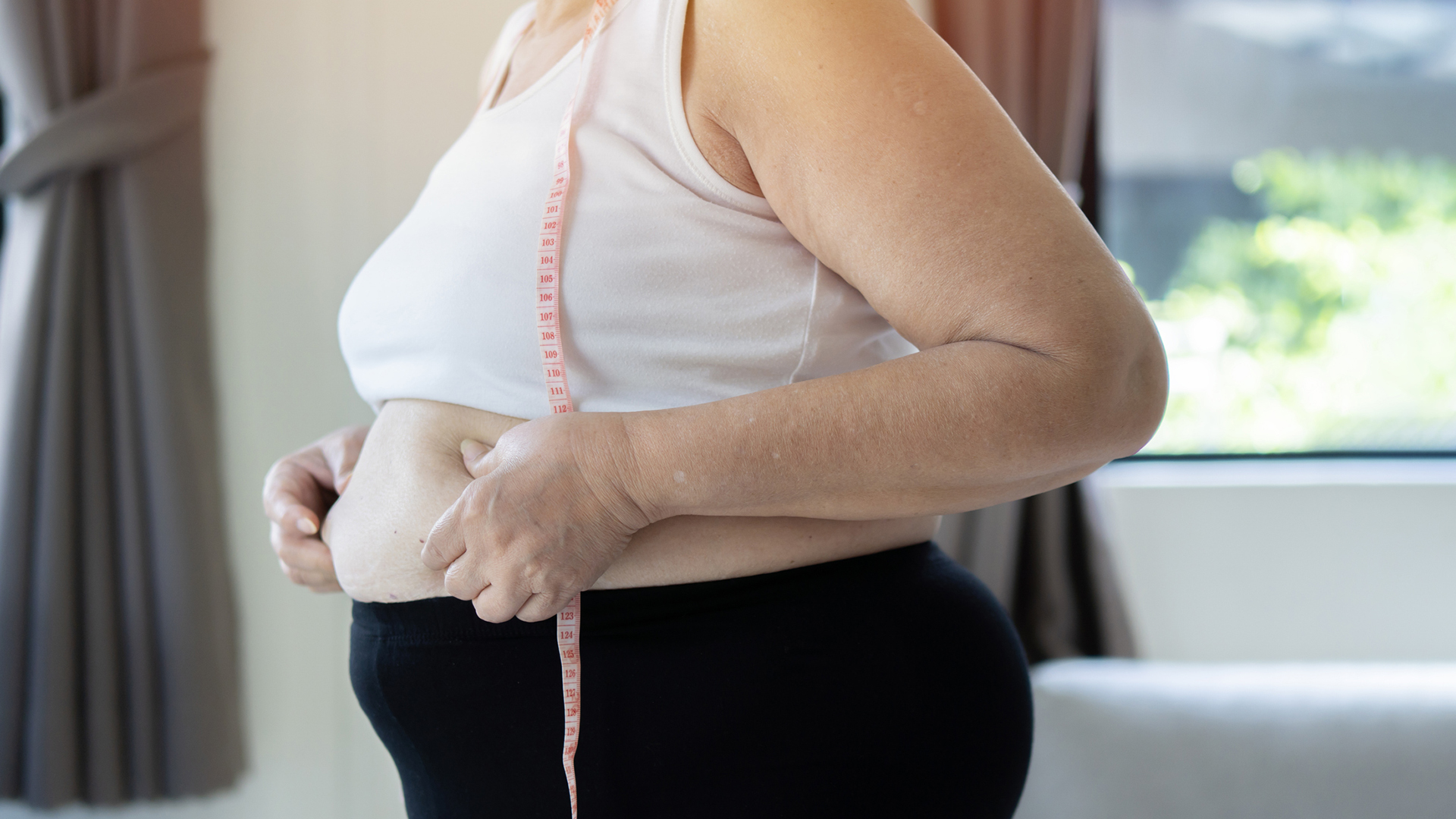 Elhízott nő a hasát vizsgálja