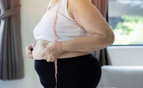 Elhízott nő a hasát vizsgálja