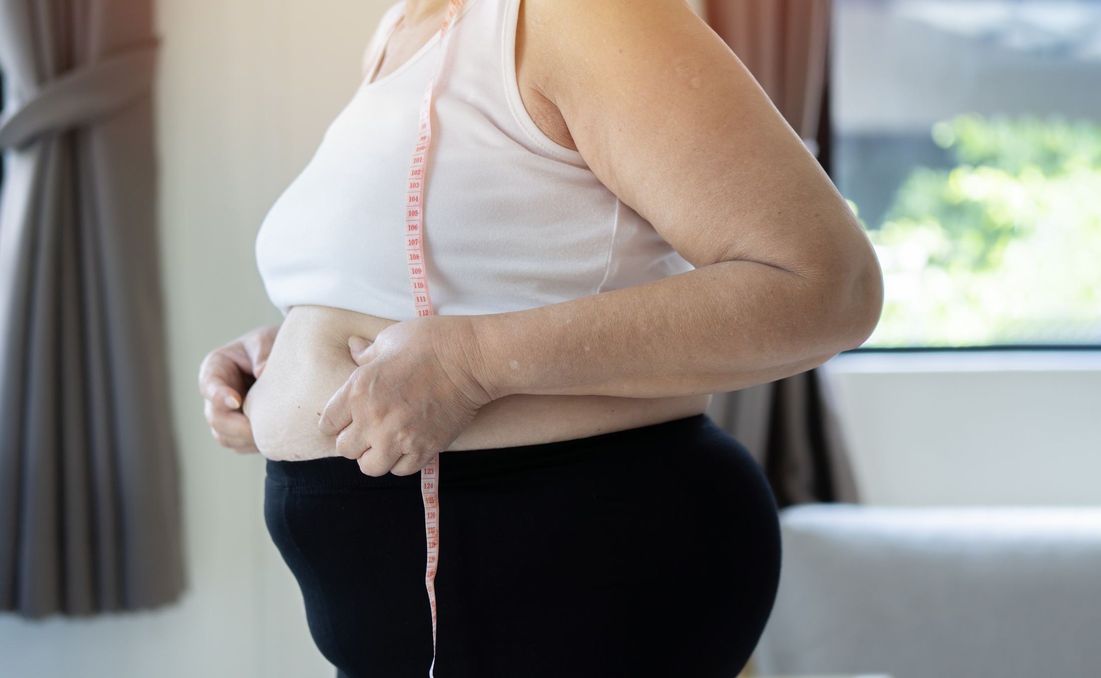 Elhízott nő a hasát vizsgálja