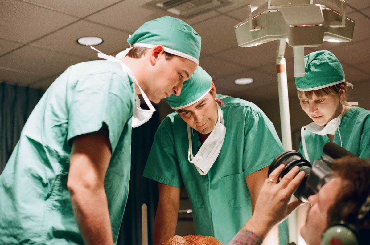 Noah Wyle és George Clooney zöld műtősruhában beteg fölé hajolnak, 1994-ben a Vészhelyzetben