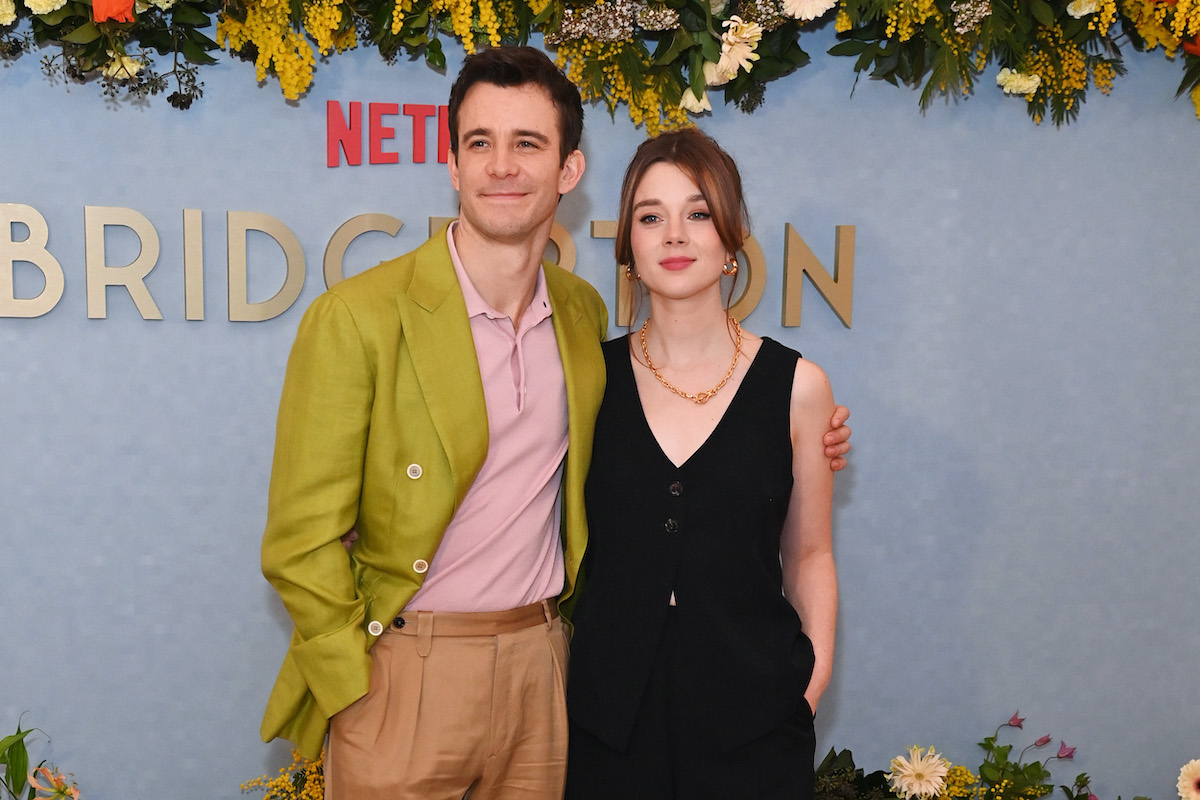 Luke Thompson zöld zakóban és rózsaszín ingben és Claudia Jessie fekete ruhában a Bridgerton 3. évad bemutatóján 2024 februárjában Londonban.