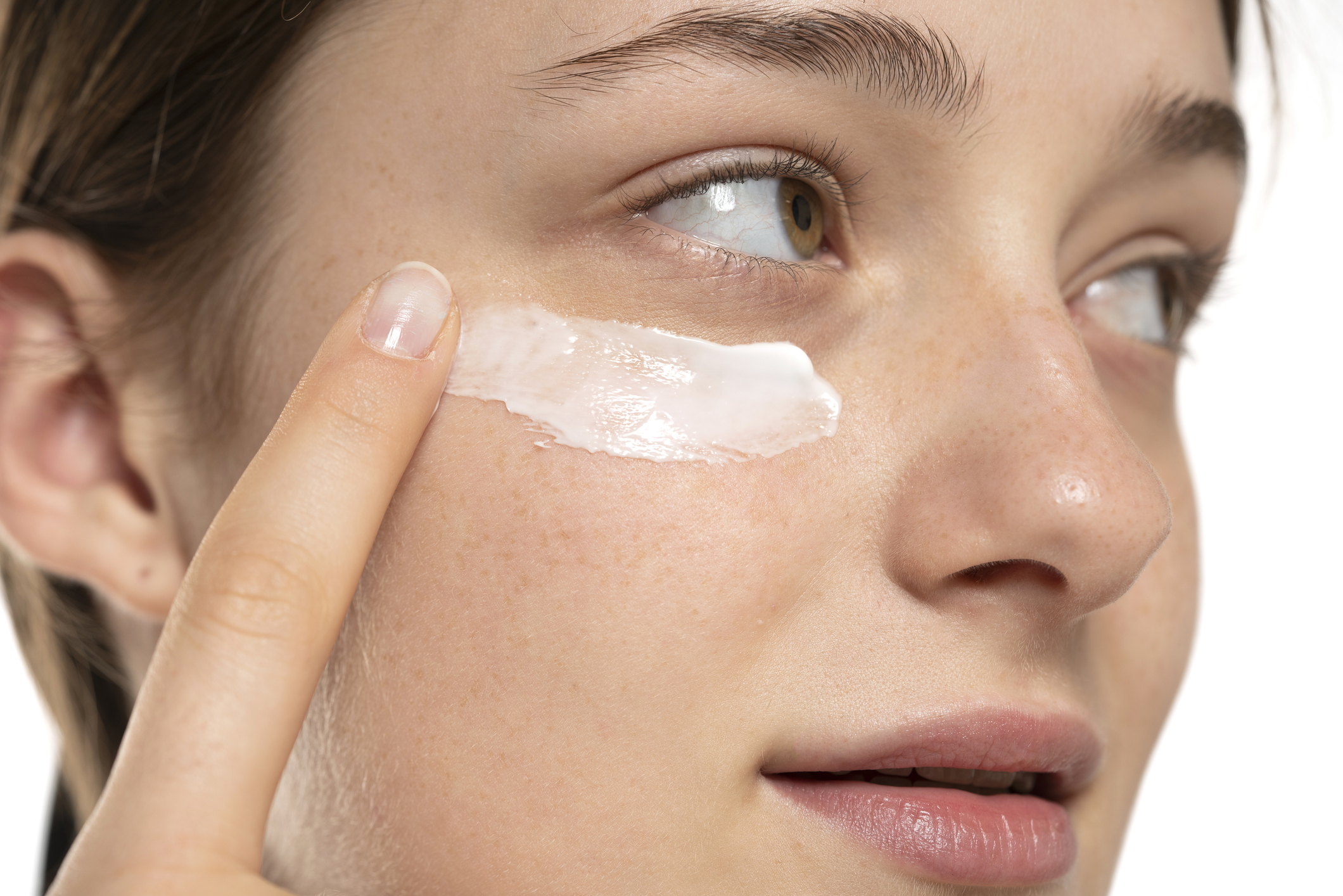 Nő krémet ken a szeme alá