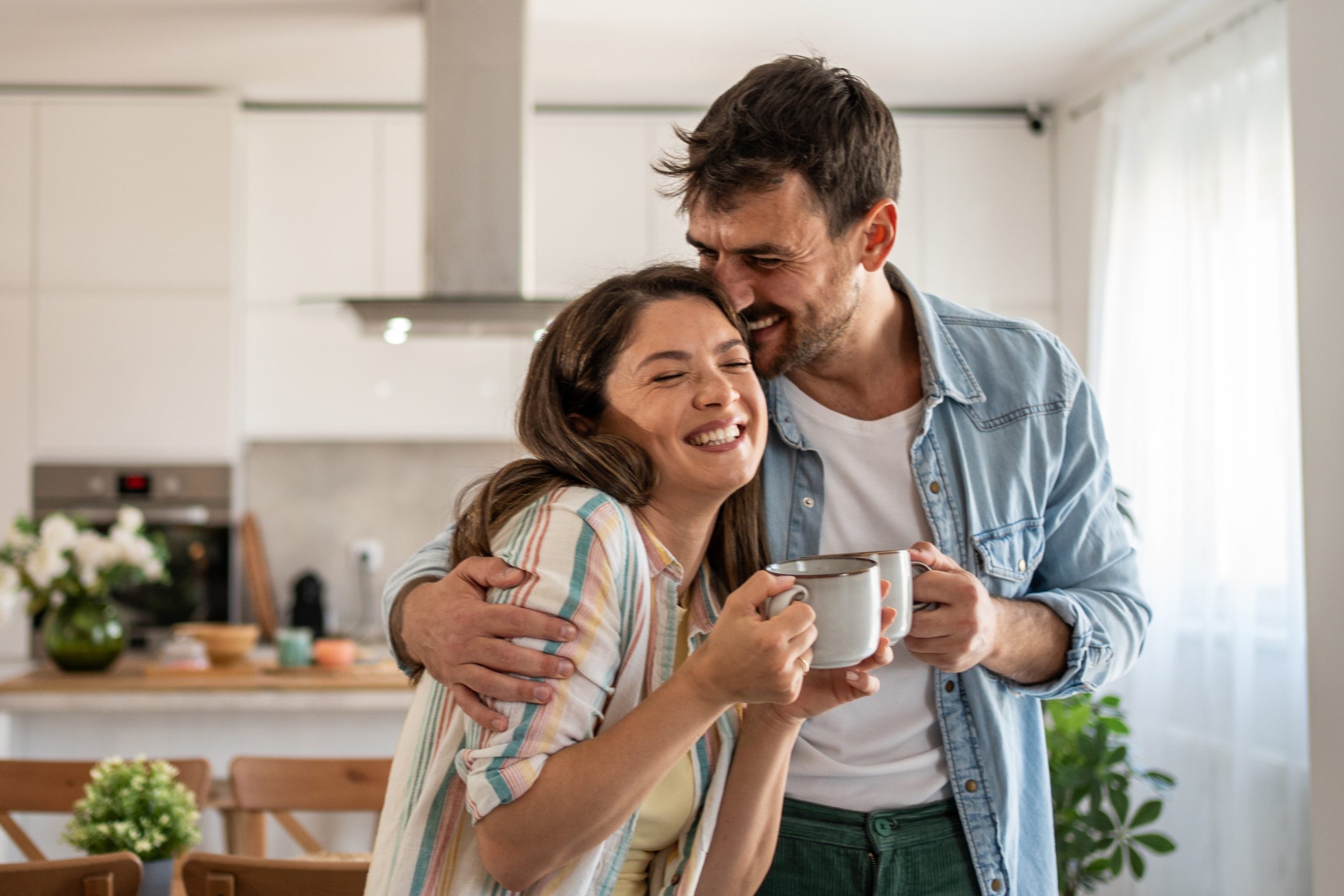 Egy boldog pár ölelkezve issza a kávéját