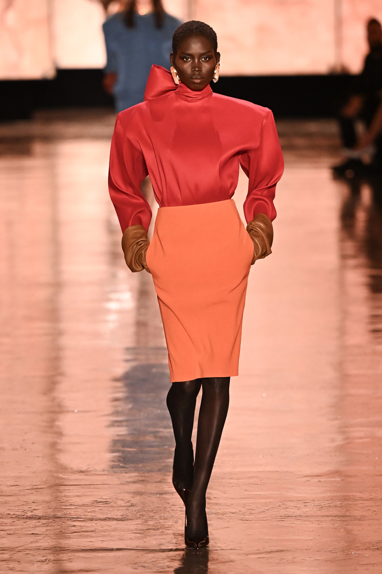 Egy narancssárga ruhát viselő modell sétál a kifutón a Saint Laurent 2025-2026-os őszi/téli női kollekciójának bemutatóján a Párizsi Divathét részeként, 2025. március 11-én, Párizsban,