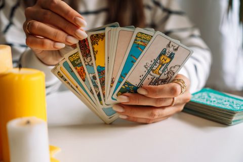 manikűrözött női kézben tarot kártyák