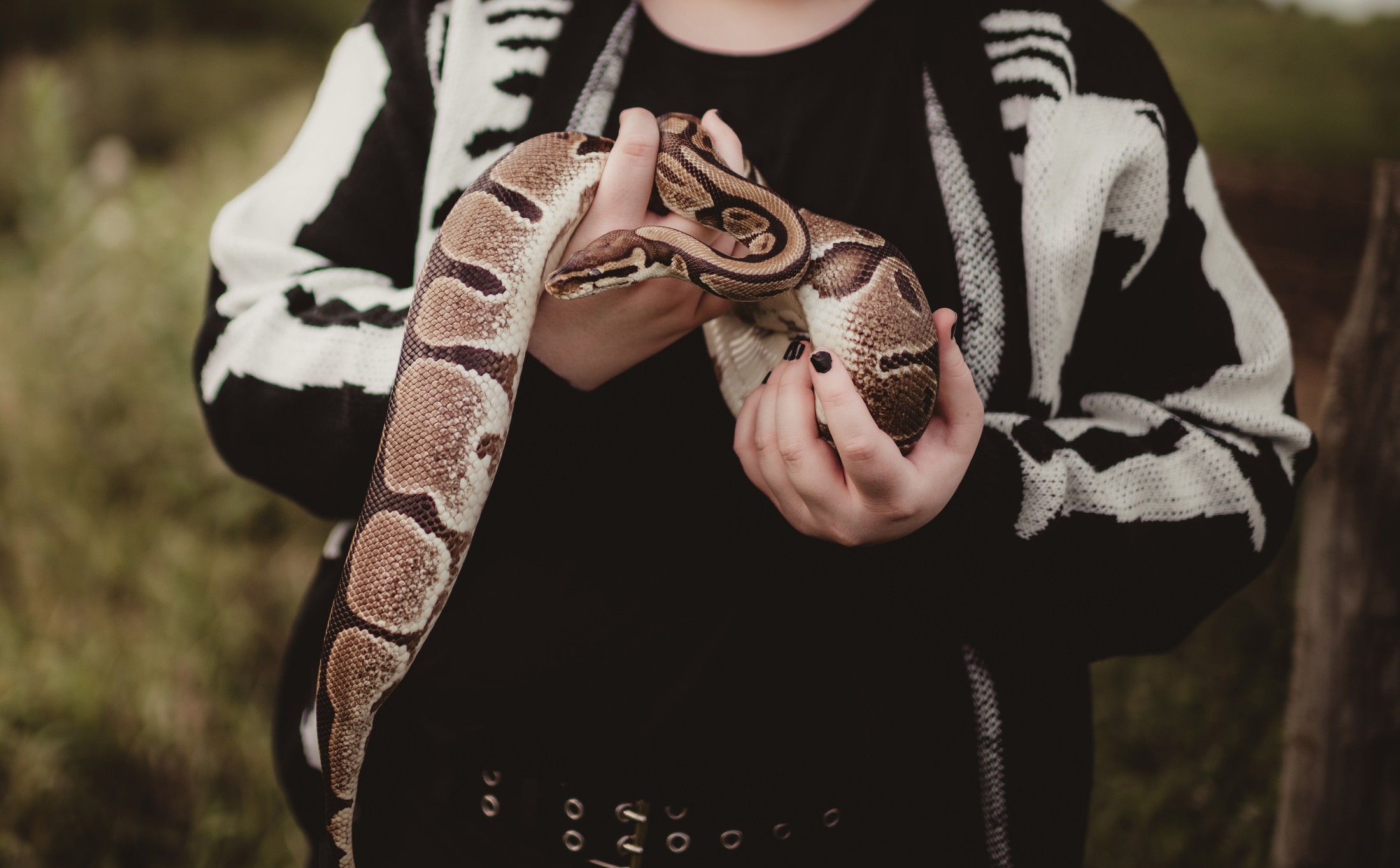 Fiatal nő kígyót tart a kezében