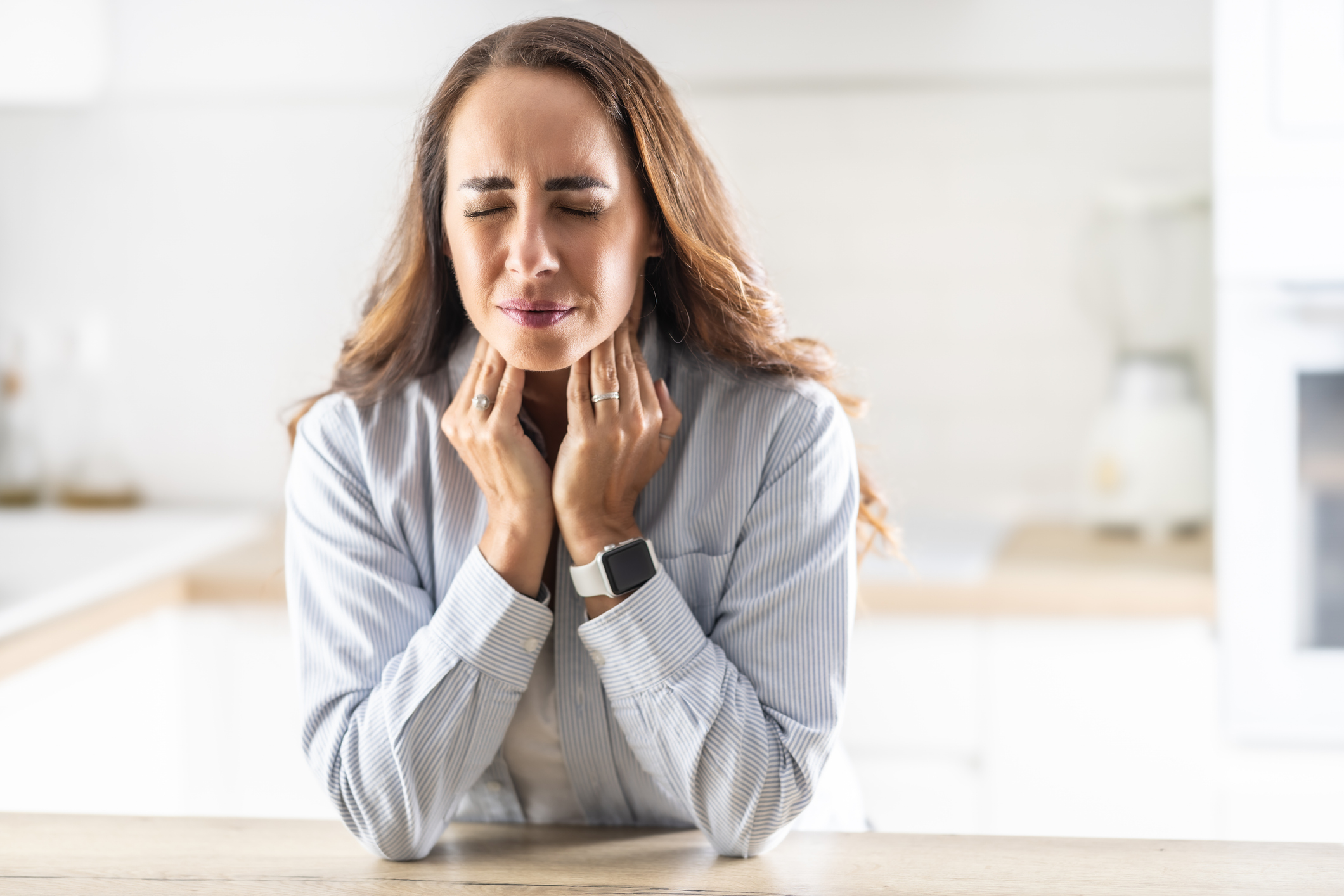 Fiatal nő megduzzadt nyirokcsomóit tapogatja fájdalmas képpel