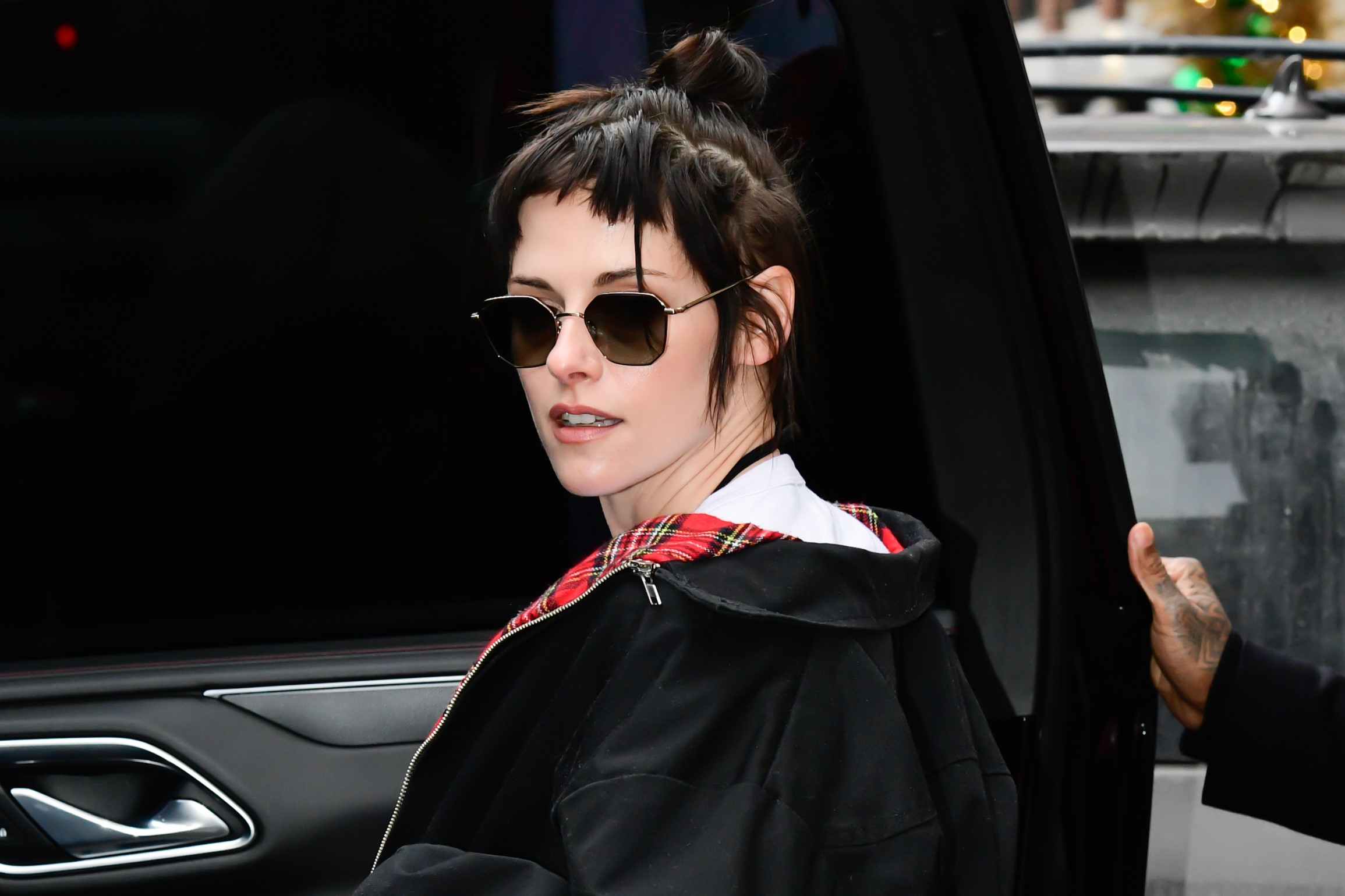 Kristen Stewart napszemüvegben, bomber dzsekiben a kamerába néz