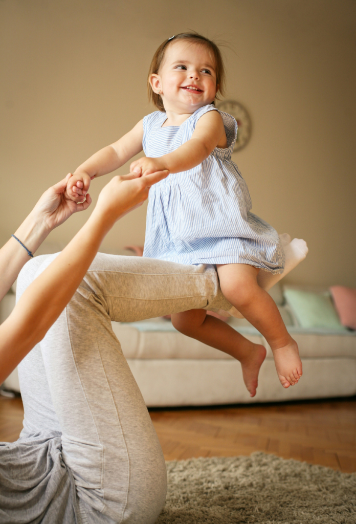 nevadasi-trendek-2026 | Marie Claire Anyuka a lábán lovagoltatja nyári ruhába öltöztetett kislányát, közben fogja a kezét