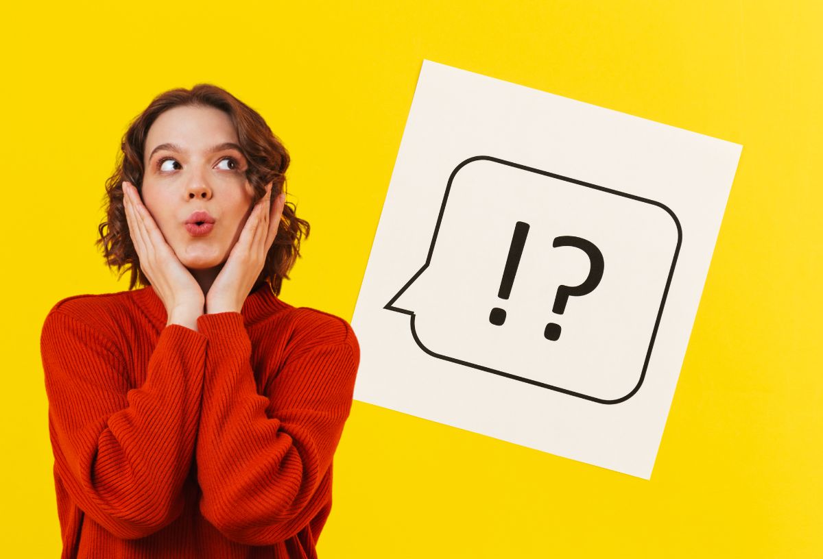 Sárga háttér, fehér négyzetben fekete gondolatfelhő rajz, benne fekete felkiáltó- és kérdőjel, csodálkozó arcot vágó fiatal nő piros pulóverben, a kezeivel az arcát fogja