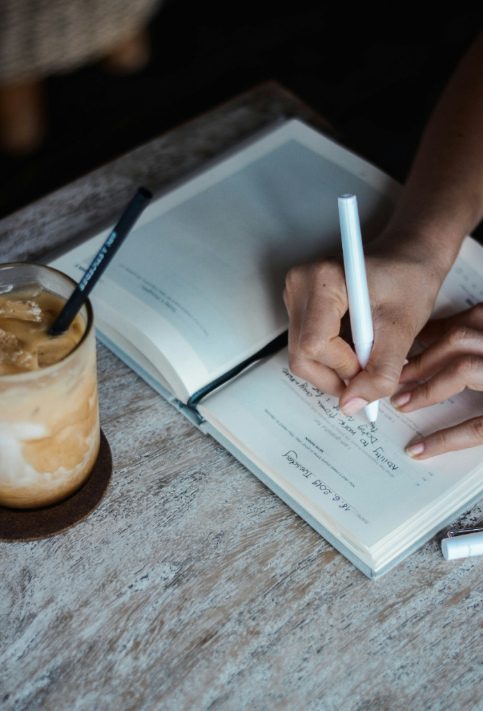 boldogsag-hala | Marie Claire Nő hálanaplót ír, mellette egy pohár jeges tejeskávé