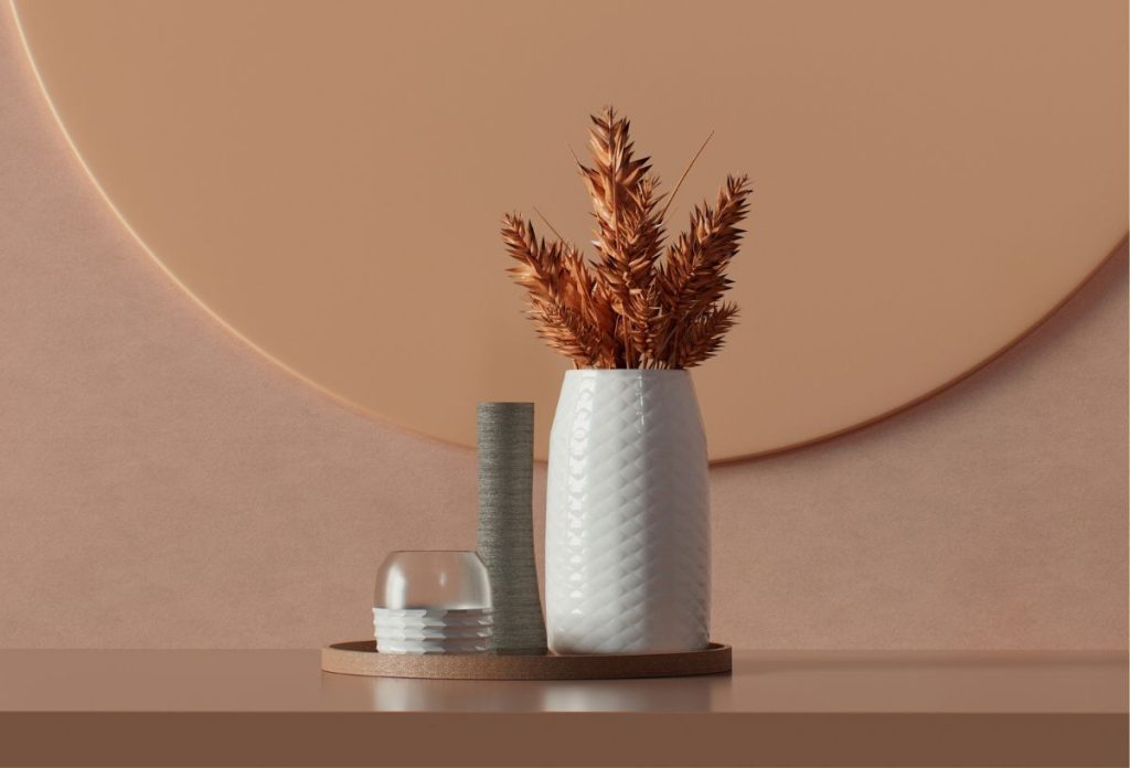 Földszínű minimalista enteriőr, tálcára rendezve fehér váza szárított növénnyel, szürke kőtömb, üveg-kerámia gyertyatartó