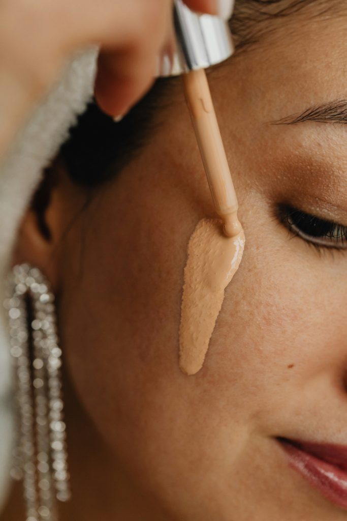 Női arc, szérumalapozót visz fel pipettával a bőrére