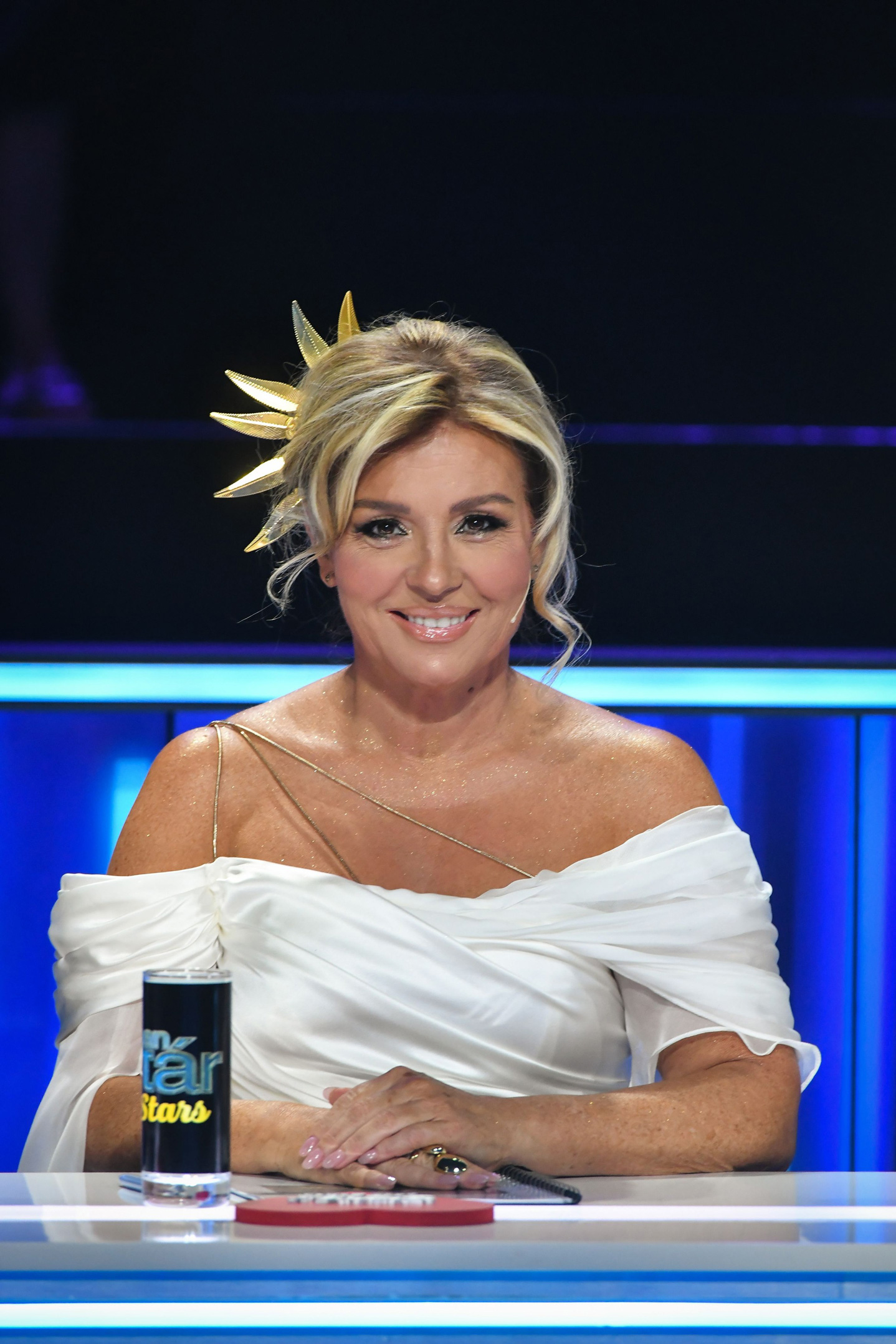 Liptai Claudia fehér ruhában a kamerába mosolyog a Sztárban Sztár című műsorban