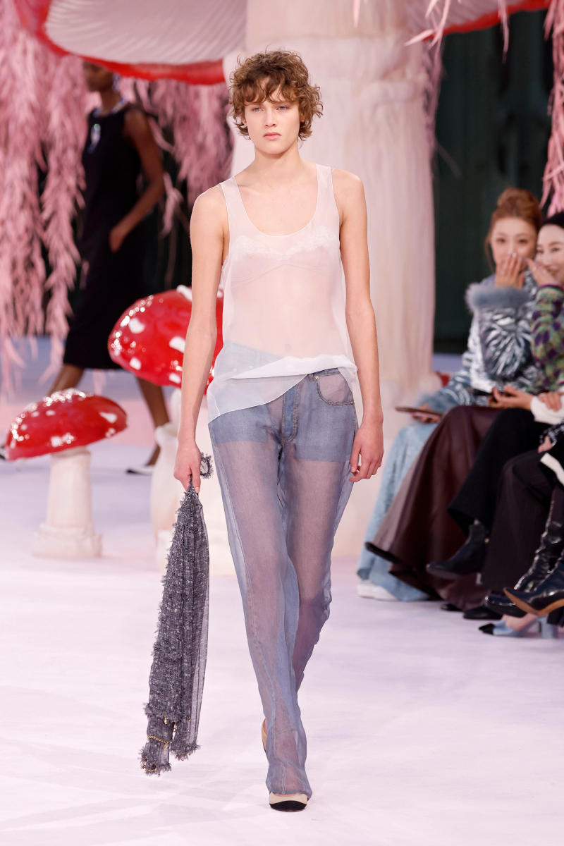 Rövid hajú modell a Chanel 2026-os tavaszi–nyári haute couture kollekciójának kifutóján áttetsző atlétában, áttetsző nadrágban