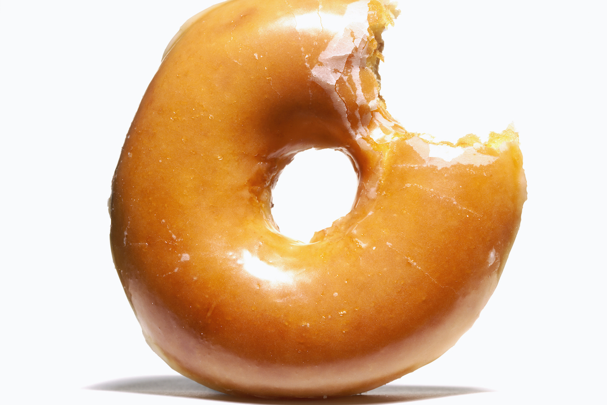 Cukormázas fánk harapással, fehér háttér előtt