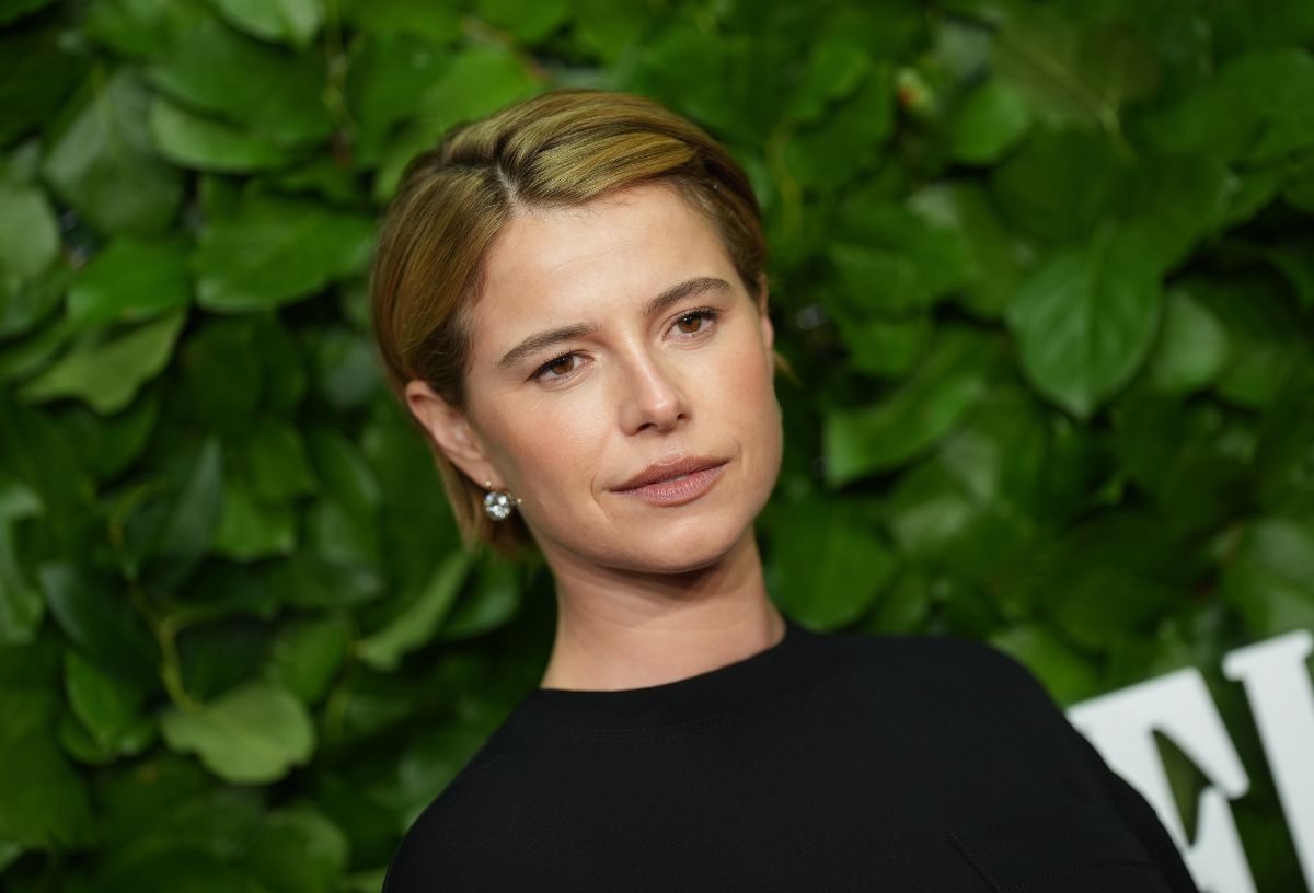 Jessie Buckley zöld növényi háttér előtt a Hamnet című film premierjén