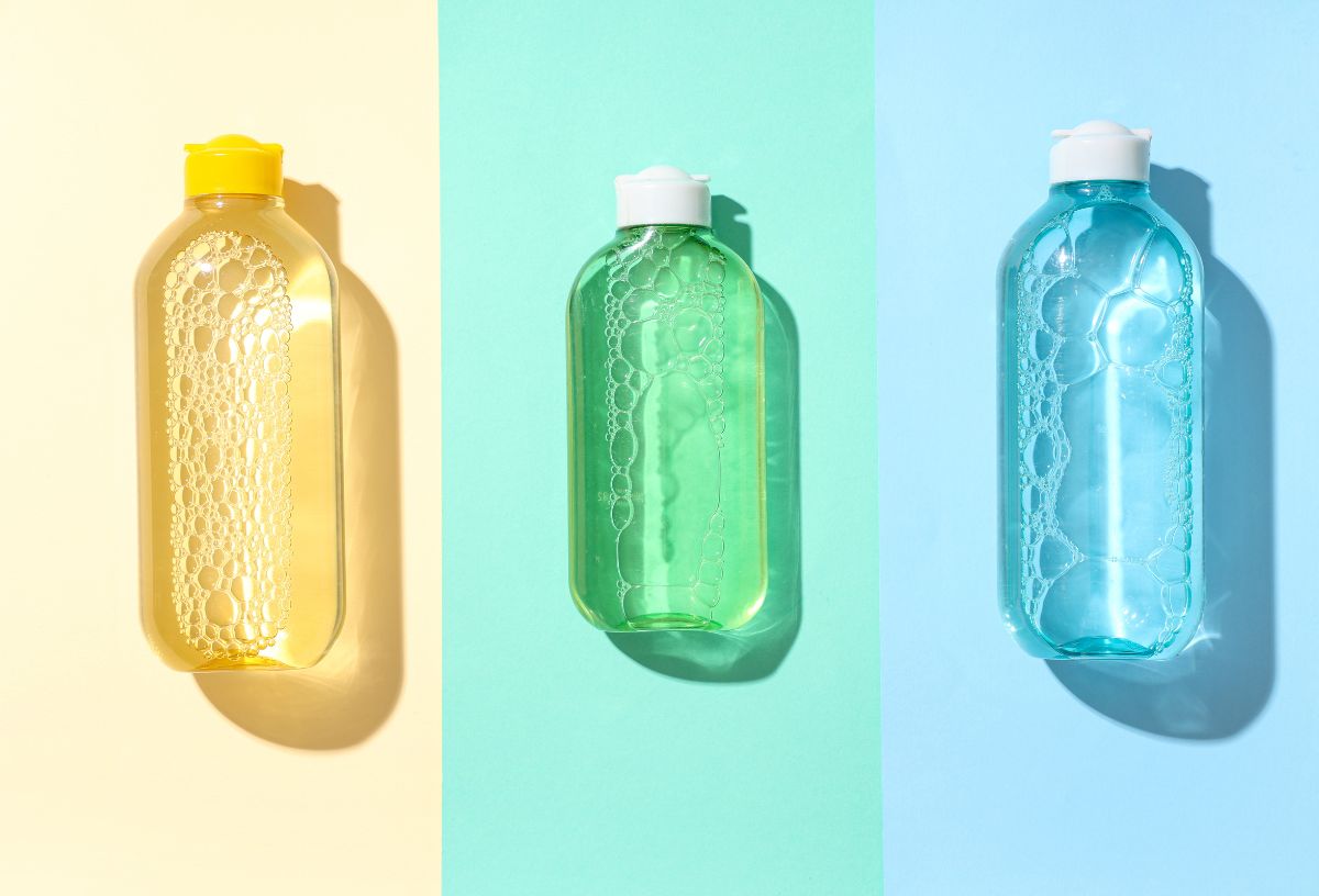 Sárga, zöld és kék micellás vizes flakon hasonló színű háttéren