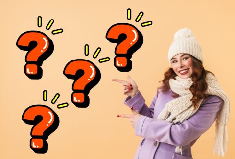 Fiatal, barna hajú nő fehér sapkában, sálban, lila szövetkabátban mindkét kezének mutatóujjával oldalra mutat, mellette piros kérdőjelek sárga vonalakkal, barackszínű háttér