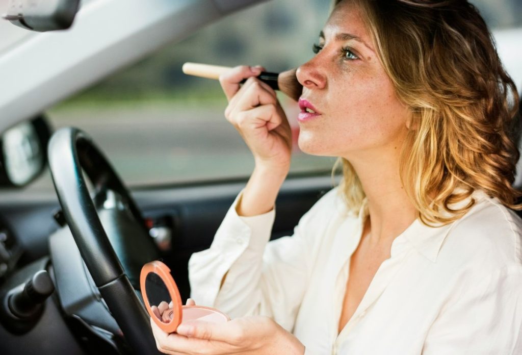 smink-faradt-hatasu-arc | Marie Claire Szőke hajú nő autóban sminkeli magát, pirosítót visz fel nagyméretű ecsettel