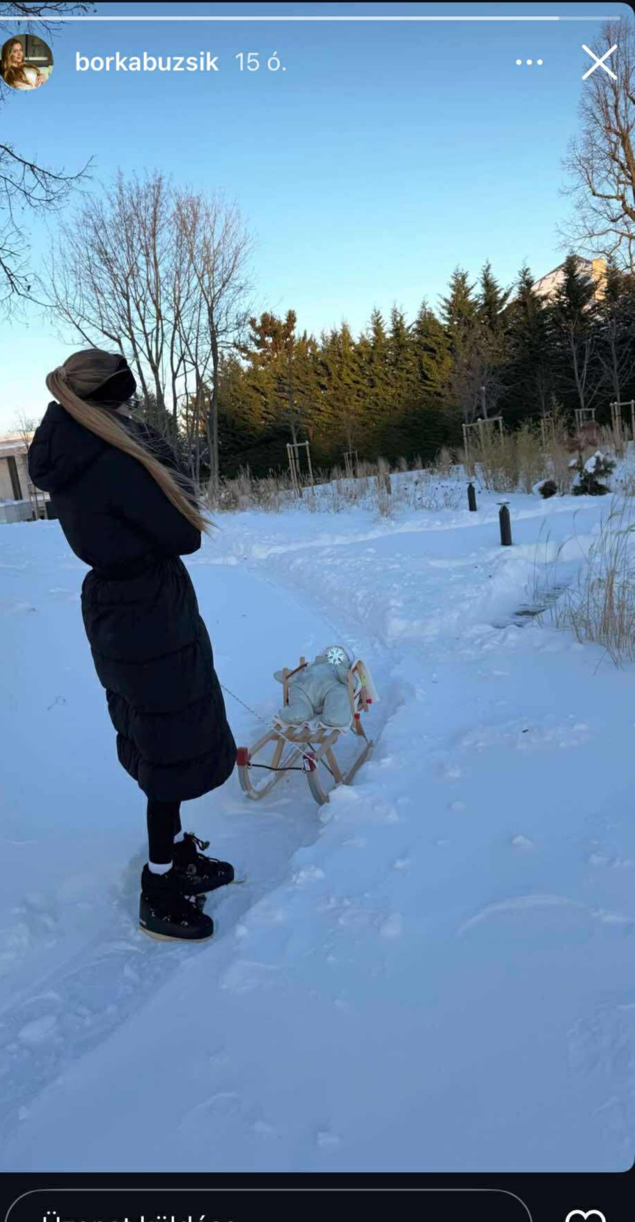 Buzsik Borka és kislánya havas tájban: a kisbaba fehér anorákban szánkón fekszik