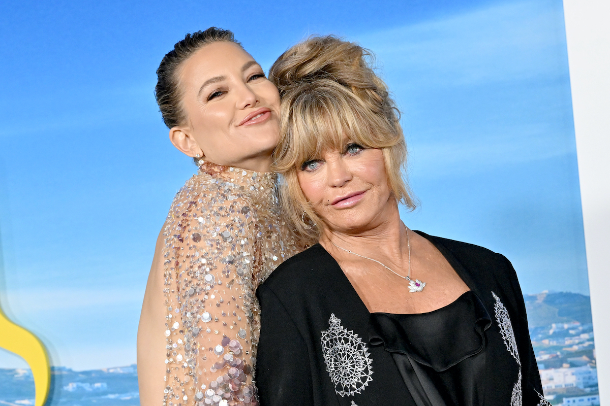 Kate Hudson flitteres ruhában és Goldie Hawn fekete felsőben kék háttér előtt