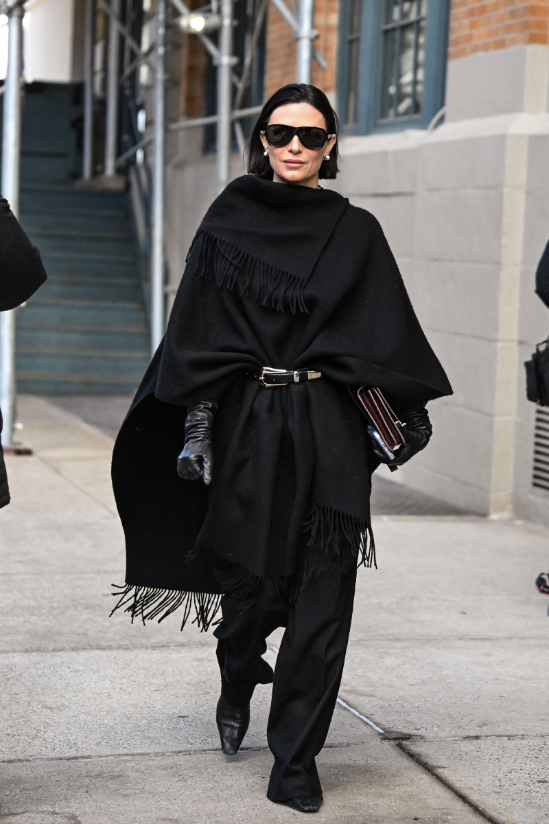 2026-new-york-i-divathet-streetstyle | Marie Claire Egy vendég fekete köpenyben, fekete nadrágban, fekete-arany övvel, fekete napszemüvegben és fekete bőrkesztyűben a Carolina Herrera show előtt a 2026-os őszi–téli New York-i divathéten.