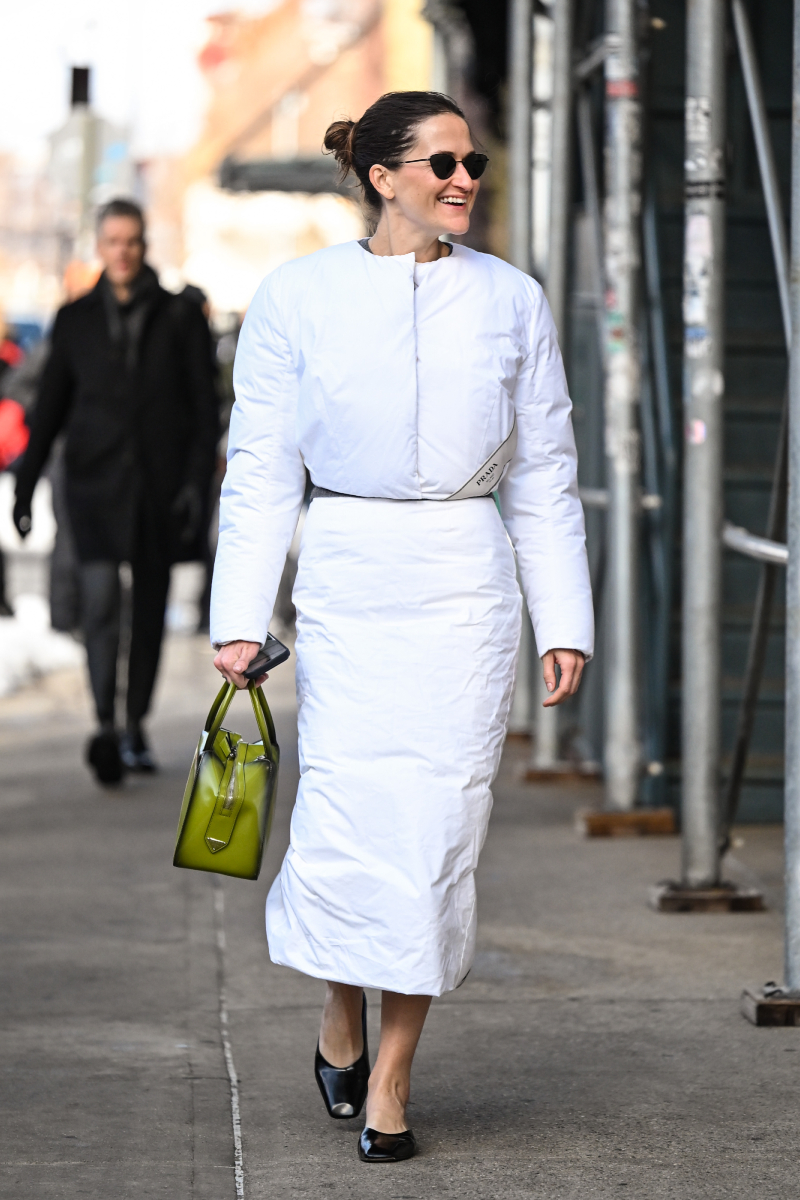 2026-new-york-i-divathet-streetstyle | Marie Claire Egy vendég fehér pufikabátot és pufiszoknyát, Prada zöld táskát, fekete cipőt és fekete napszemüveget visel a Carolina Herrera show előtt.a 2026-os őszi–téli New York-i divathéten.