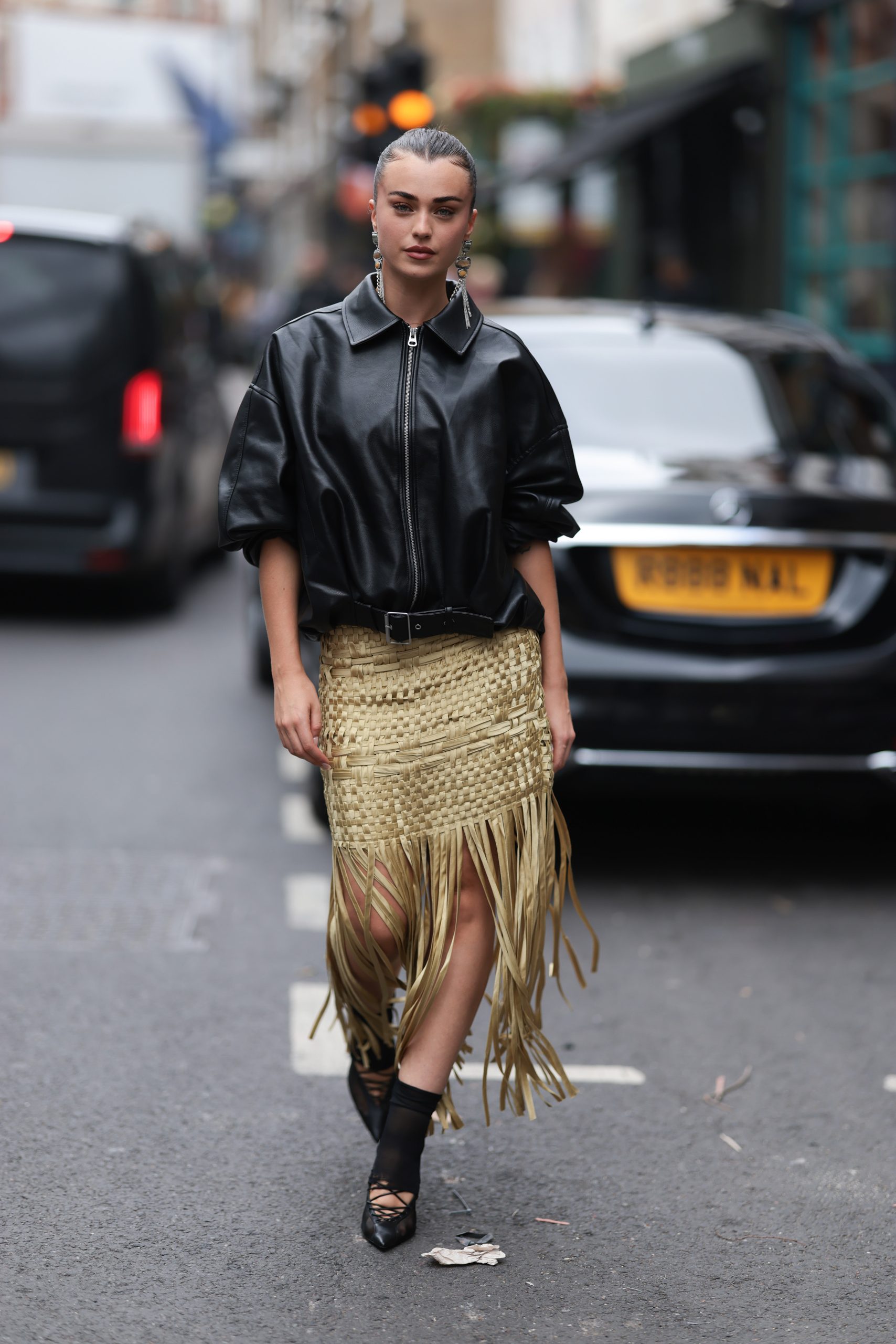 Modell statement szoknyában pózol az utcán