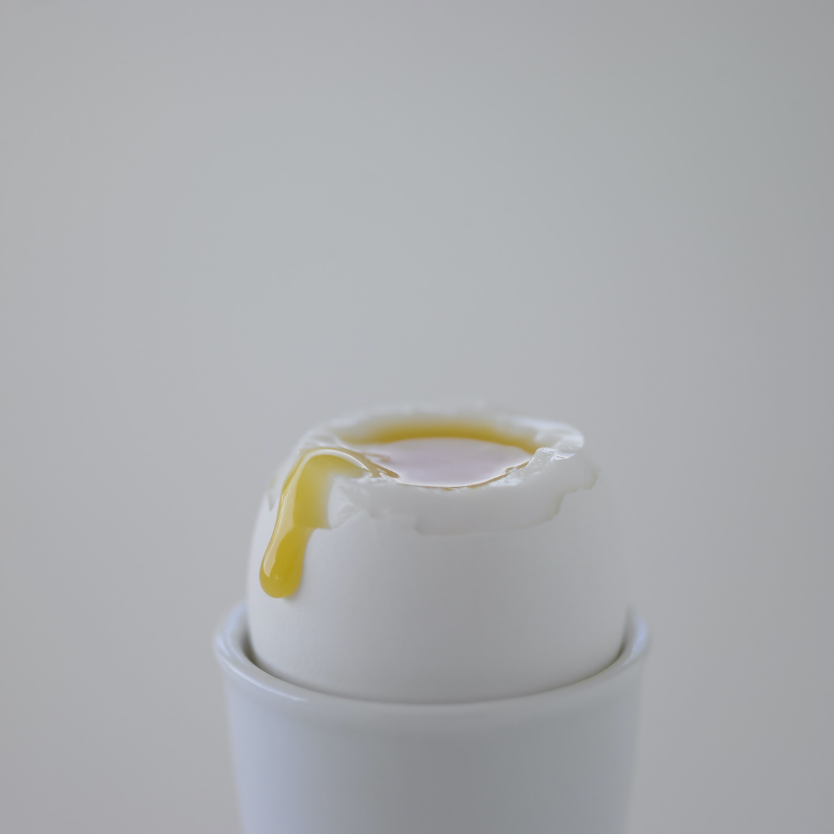 lágy tojás fehér háttér előtt, fehért tojástartóban