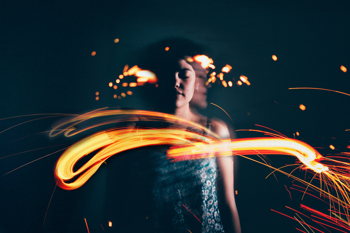 női portré elmosódott tűz képével az előtérben