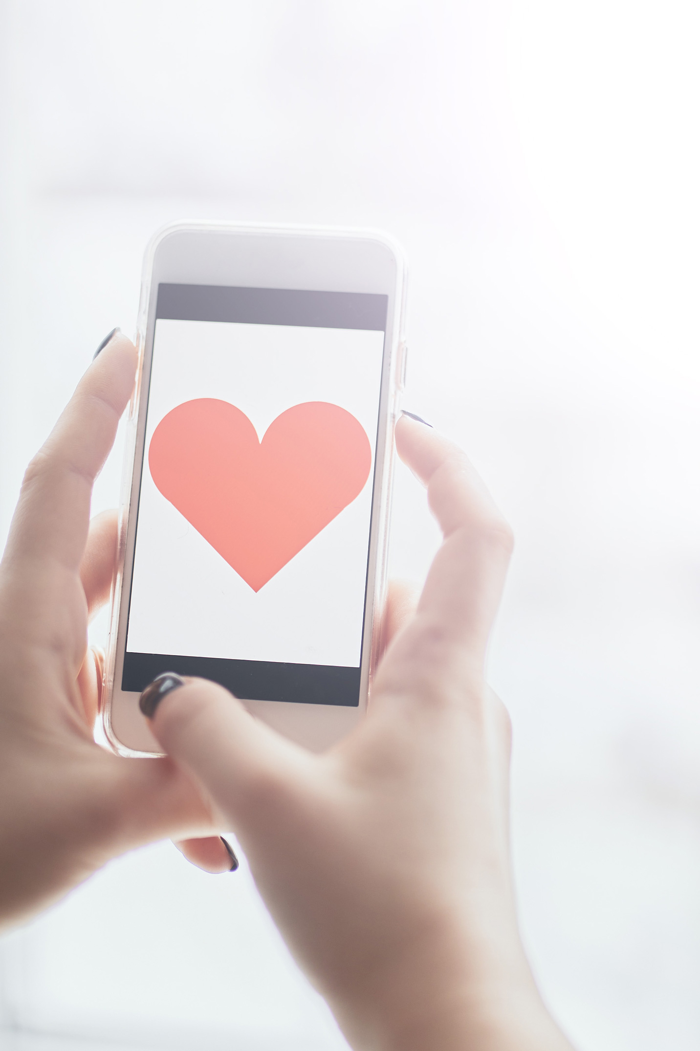 tarskereses-szerelem-tel-osz | Marie Claire Egy női kéz egy mobilt fog, aminek a kijelzőjén egy szív van
